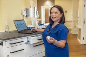 A nurse at the nurses' cart in the hallway at Lakewood Post Acute