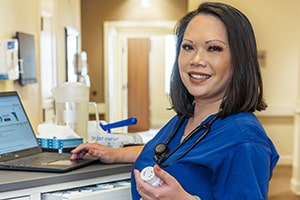 A nurse at the nurses' cart in the hallway at Lakewood Post Acute